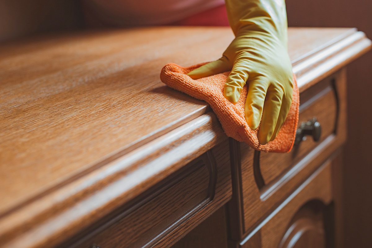 Cleaning and maintenance of wooden furniture chair table with rag and cleaning agent