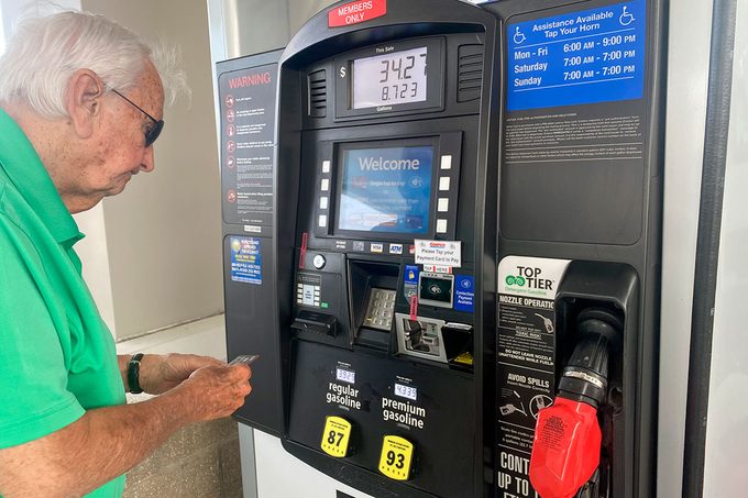 Mature adult man filling tank at gas pump