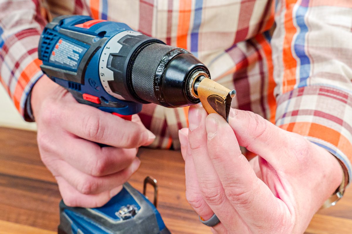 sanding a nail smooth with a drill press