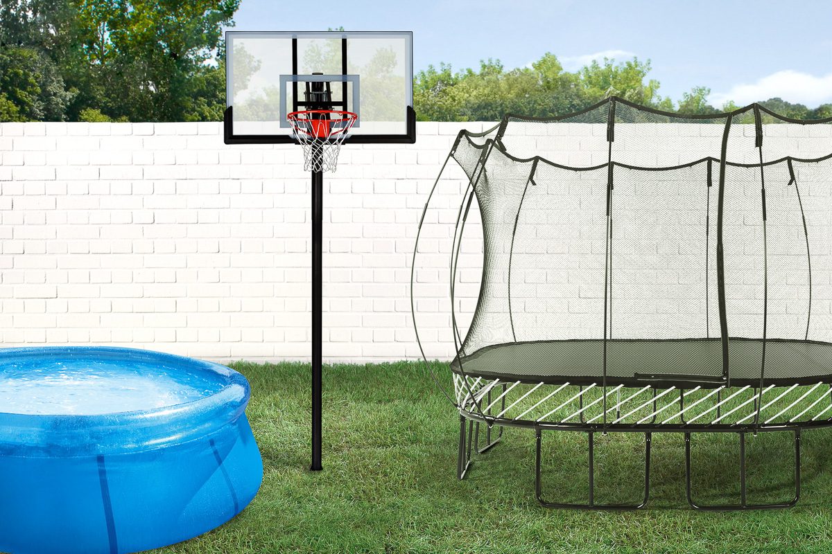 trampoline, pool and basketball hoop in backyard