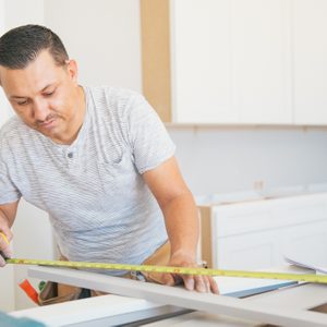 Using a measuring tape for kitchen installation.