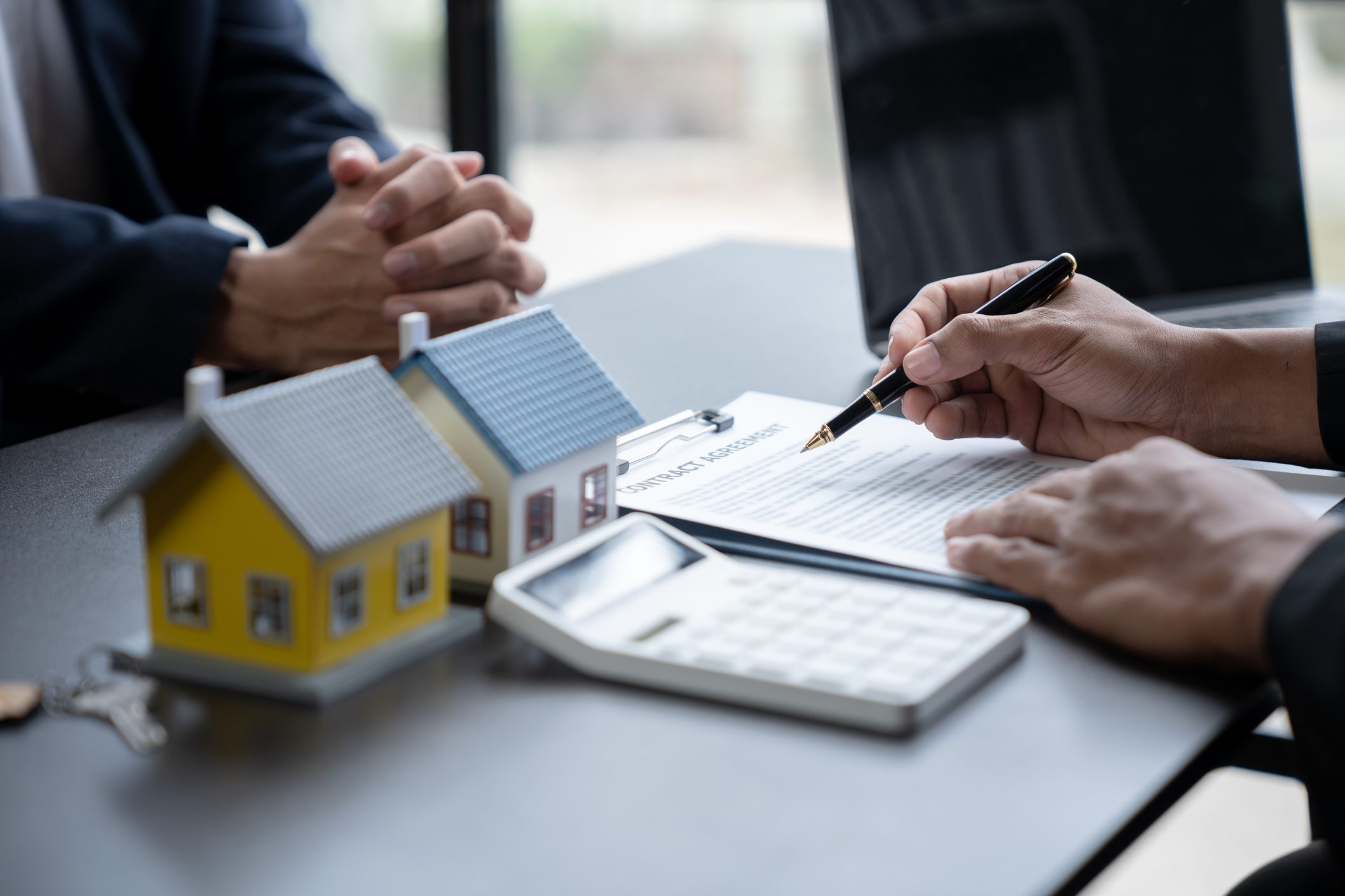 Young Asian home sales agents, insurance agents, and real estate agents offer young Asian entrepreneurs information on price conditions when signing a contract to buy rent house in the office.