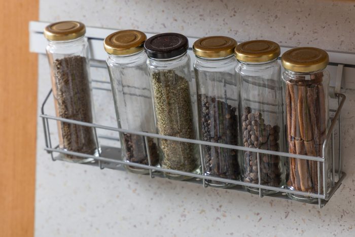 Spices in jars stored on a shelf in the kitchen
