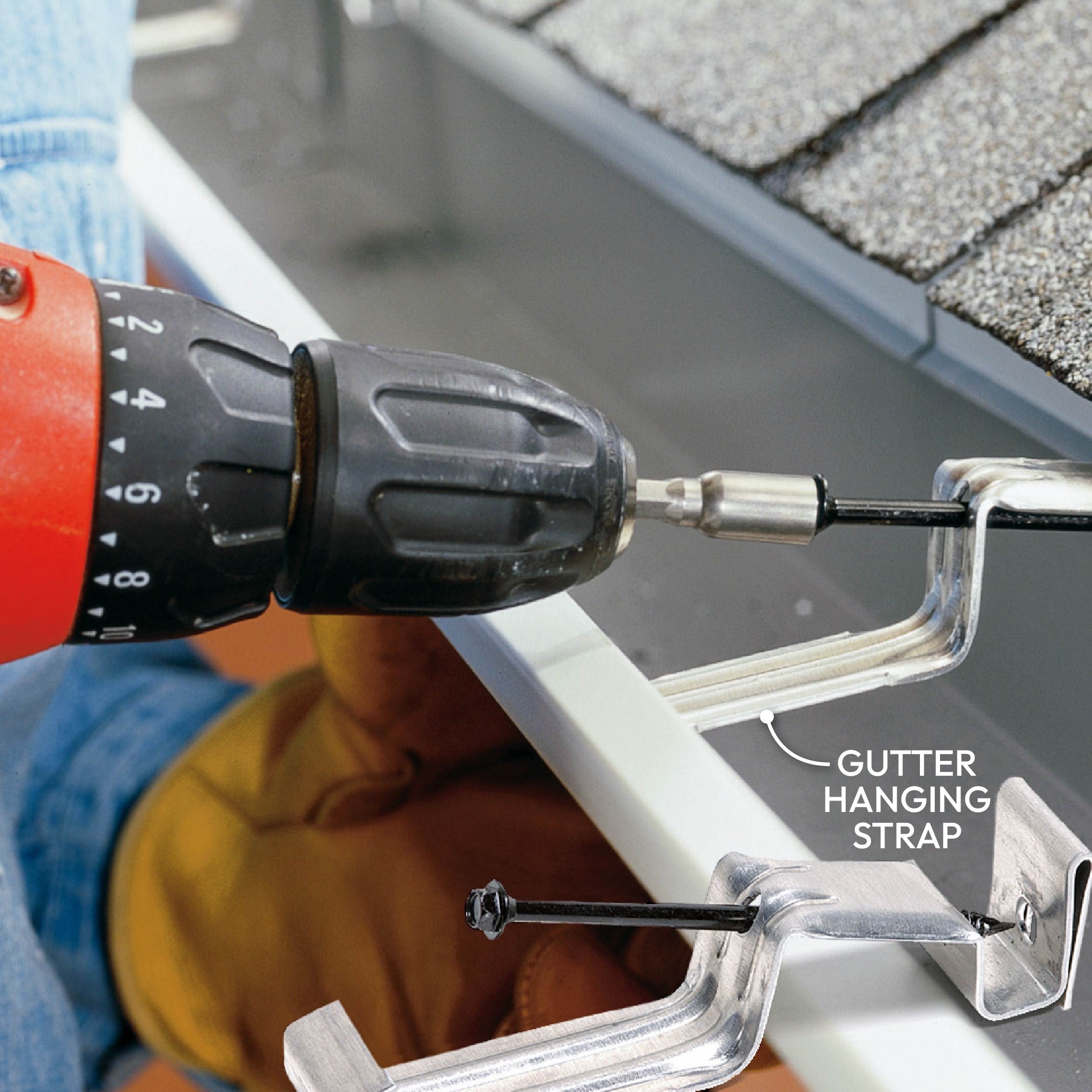 A drill attaches a gutter hanging strap to a roof, demonstrating a home improvement task with shingles and a gutter in the background.