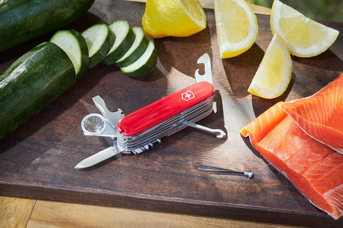 A Swiss Army Knife placed on a table around vegetables