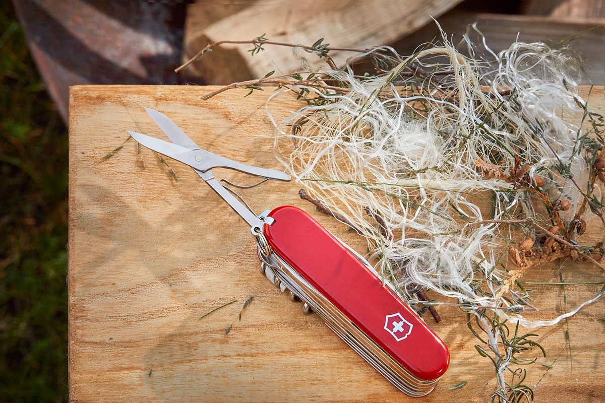 A swiss army knife plced near a wood to start the fire