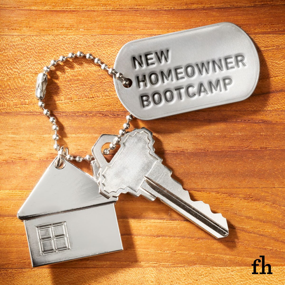 keychain on wood background: One house-shaped keychain, one house key, and one dog tag that reads 