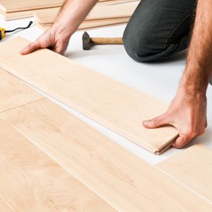 Close-up of man putting hardwood floor panels, floorboards