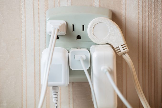 Electrical socket overloaded on wall.