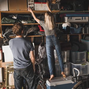 man looking at woman arranging boxes