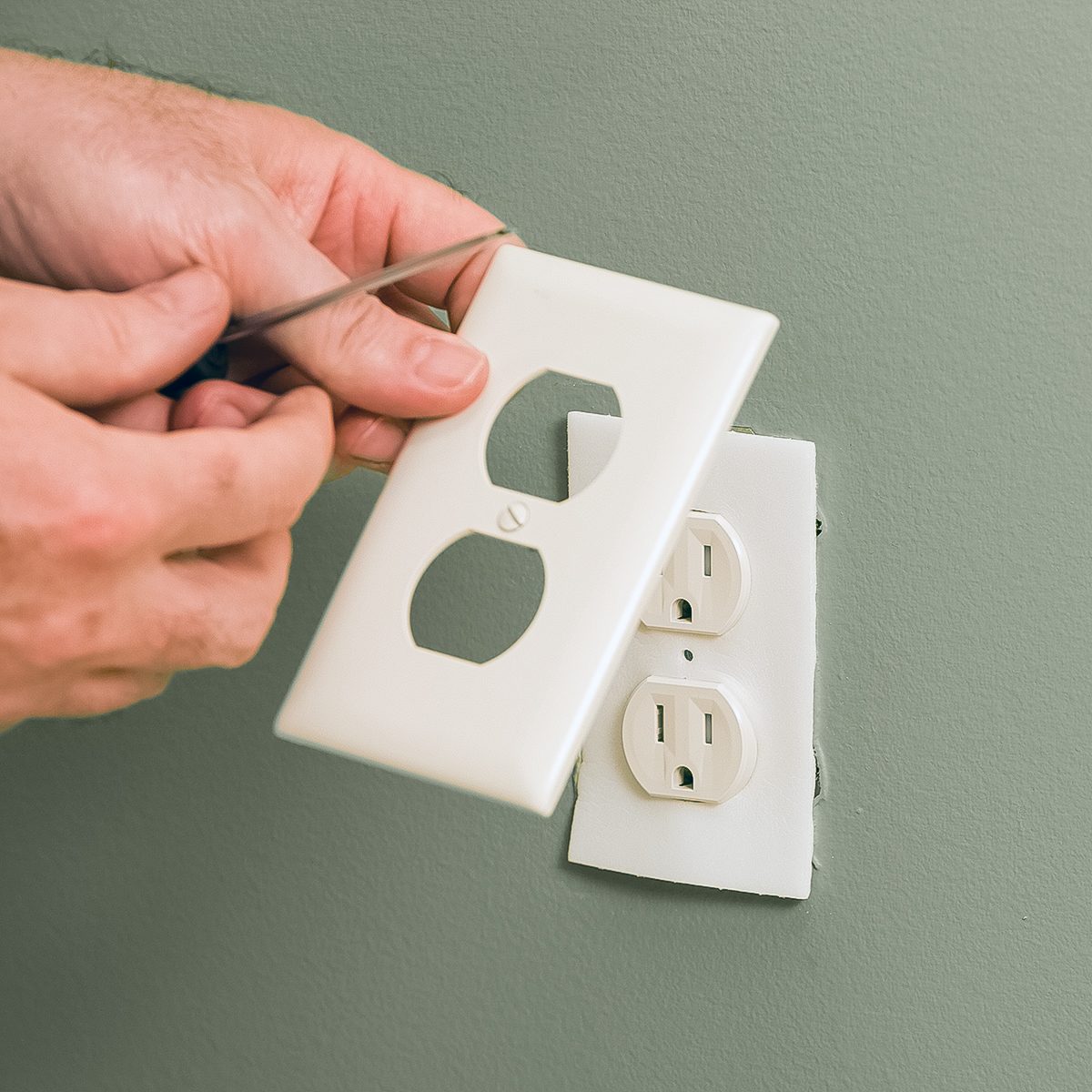 Electrician Installing Electric Outlet Insulation Pad