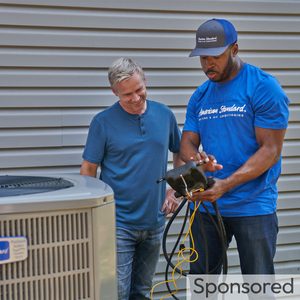 American Standard Dealer showing a man a display with unit outdoors