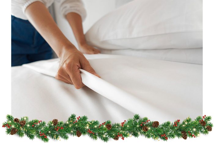 Female Hand set up white bed sheet in bedroom